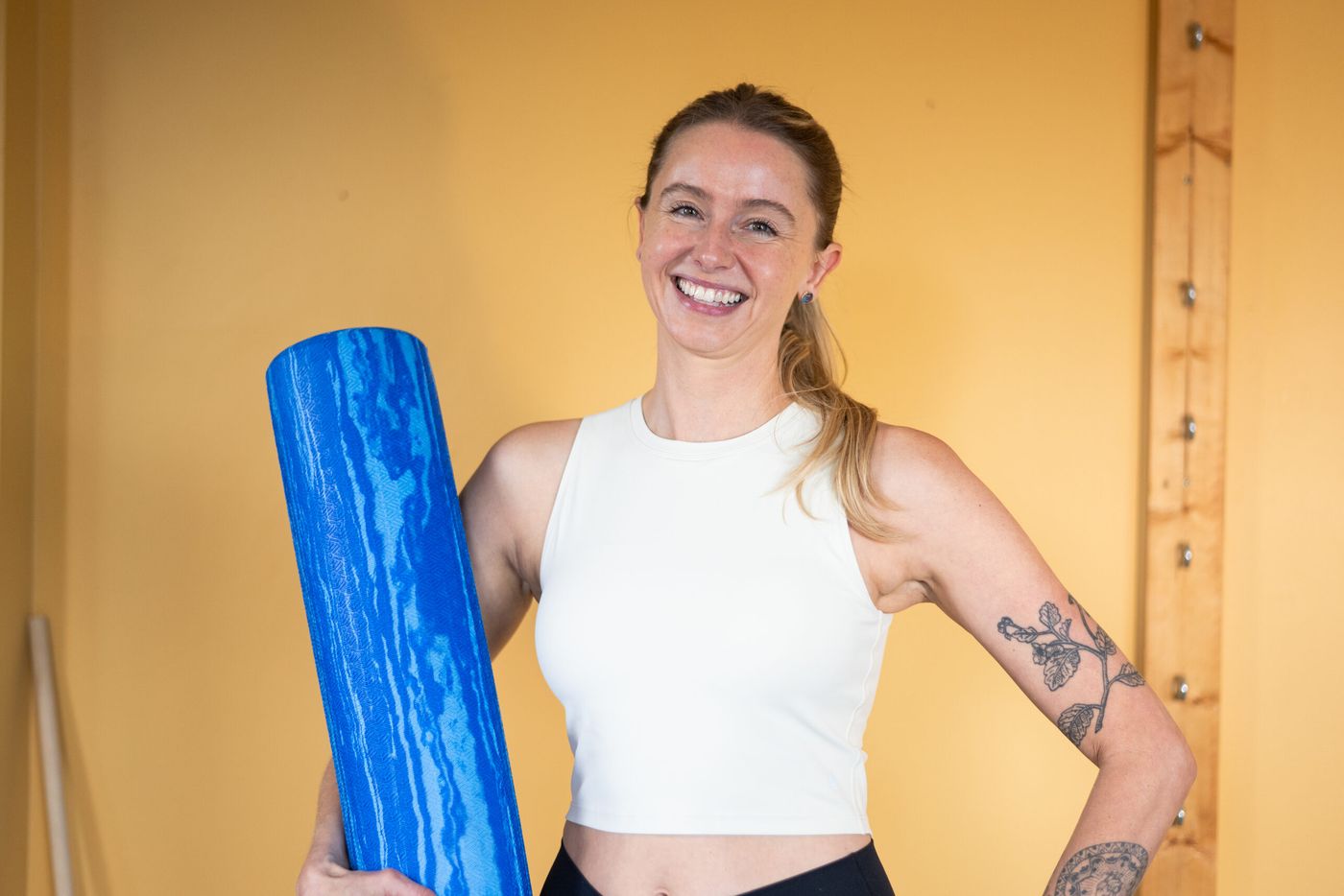 Caroline holding a foam roller and smiling