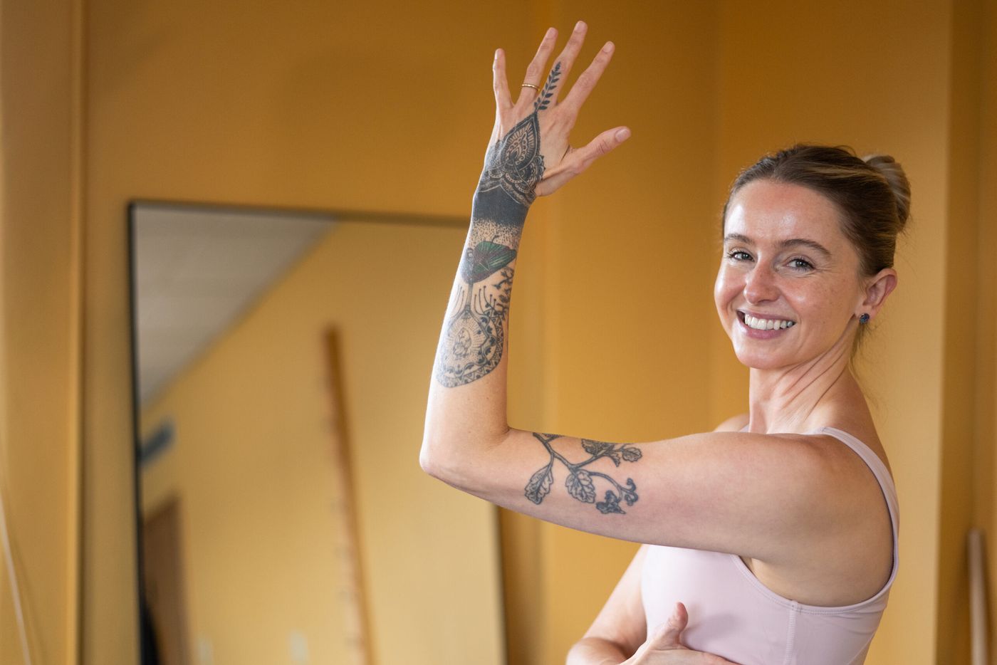 Caroline raising one arm and smiling toward the camera