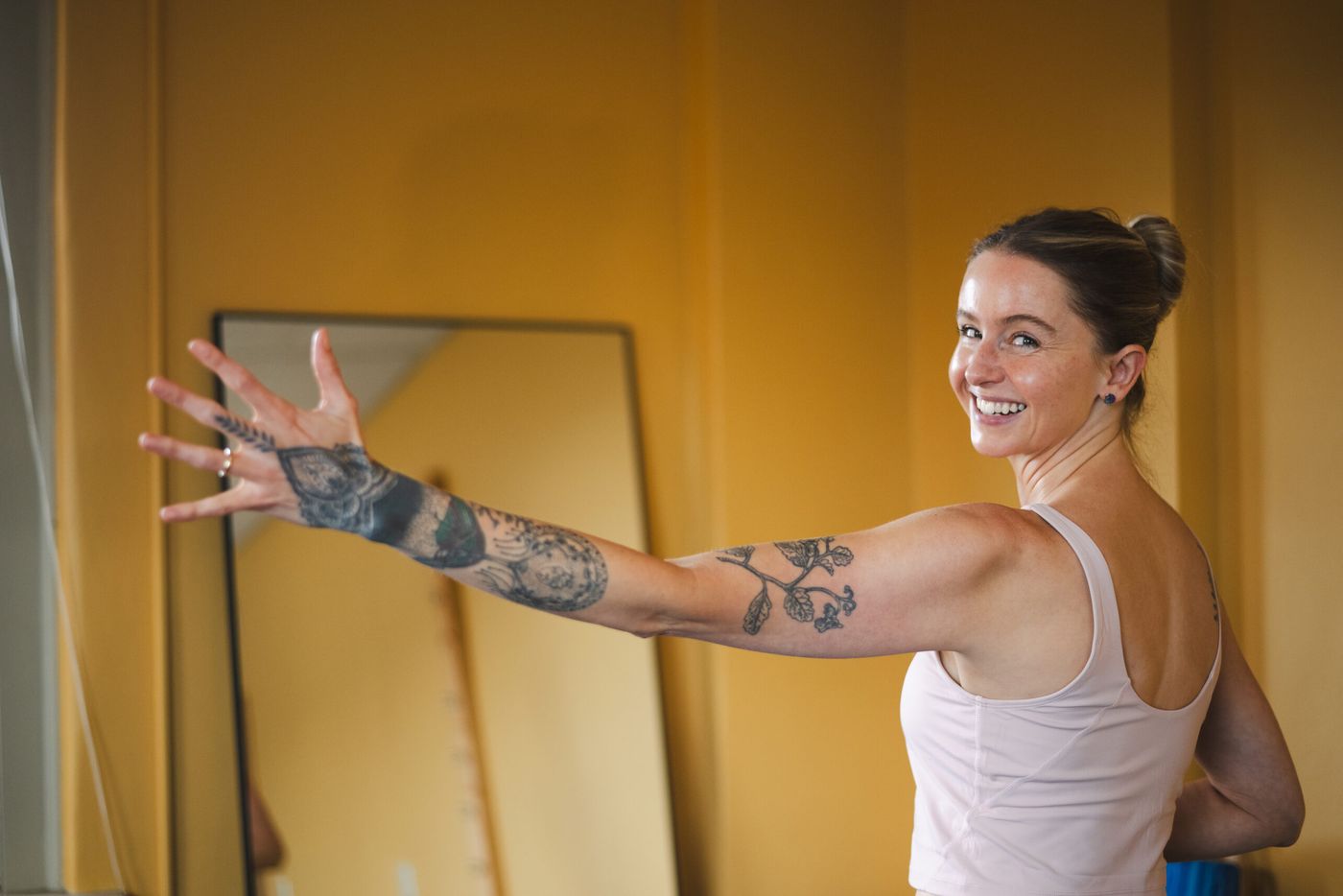 Caroline smiling over her shoulder, arm stretched out, in her movement space
