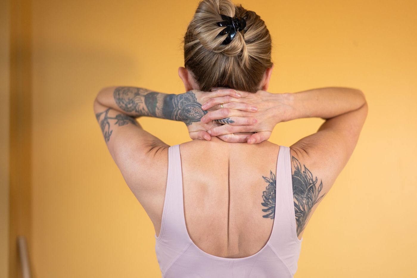 Caroline from behind, hands clasped behind her head, showing shoulder position