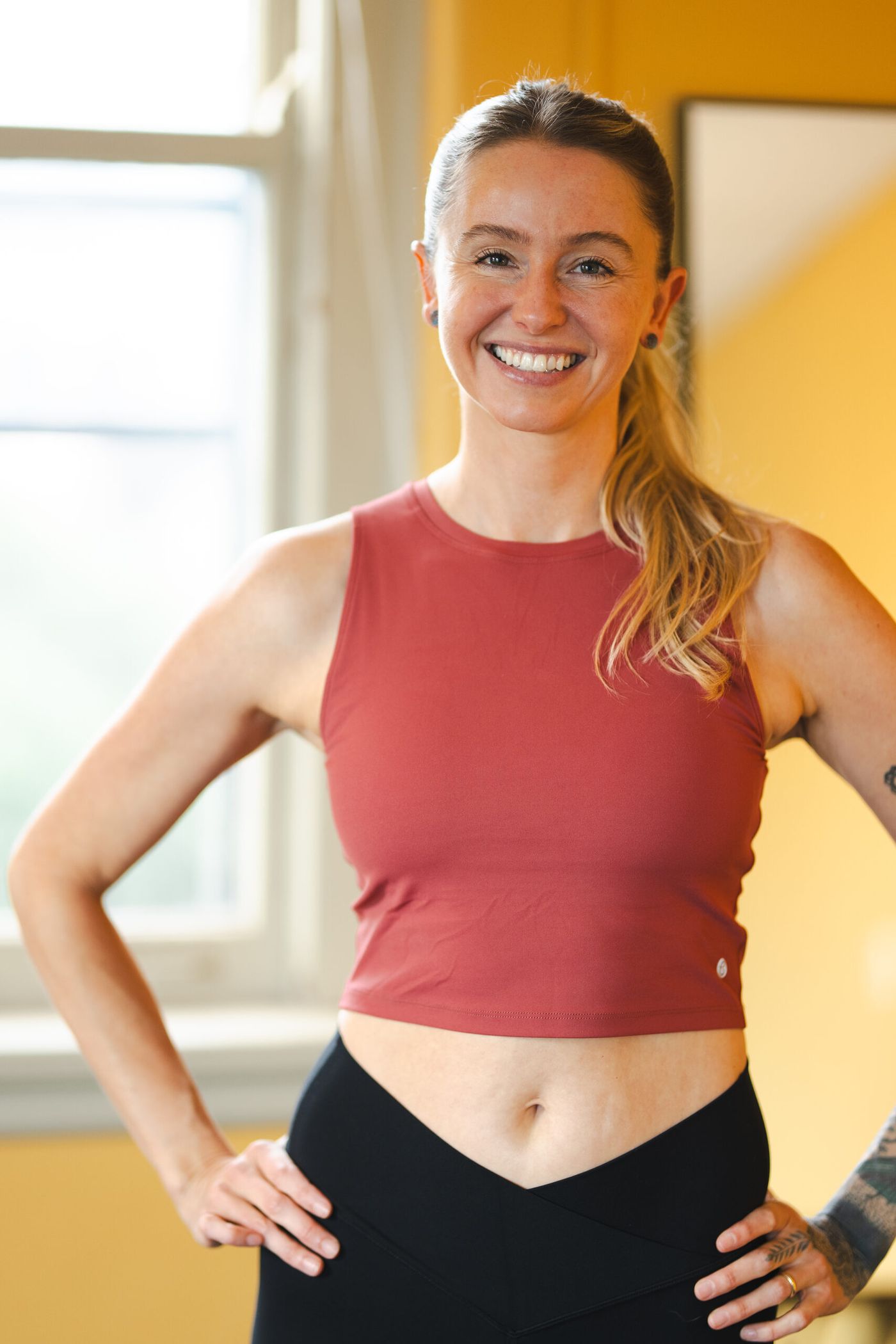 Caroline Johnson standing with hands on hips by the studio window